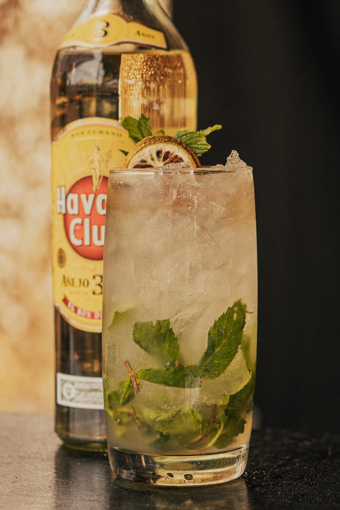 Close-up of a refreshing mojito cocktail with mint and lime in front of a Havana Club bottle.